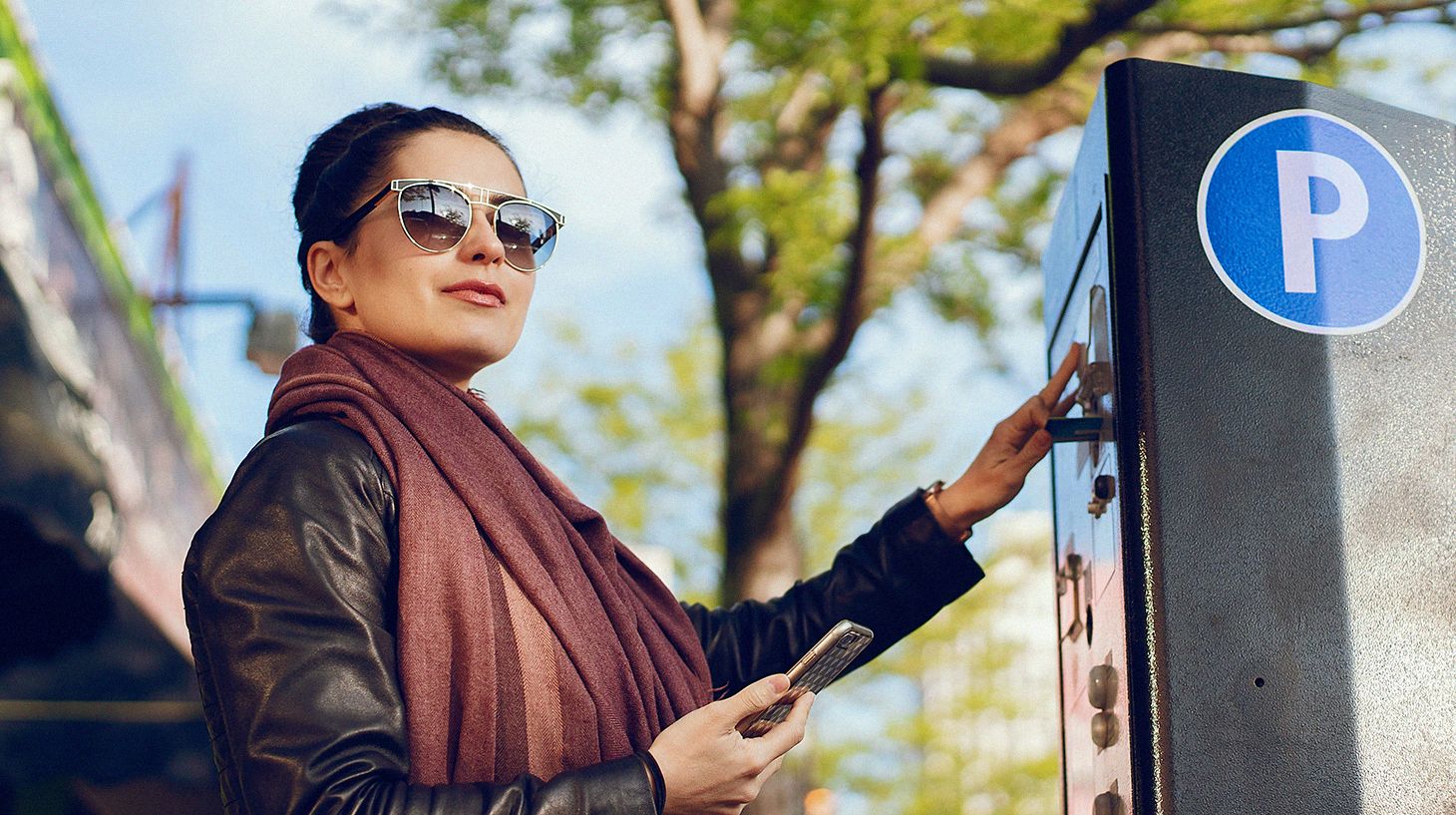 Femme achetant un permis de stationnement à une borne de paiement